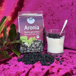 Tørrede aroniabær ved siden af yoghurtglas