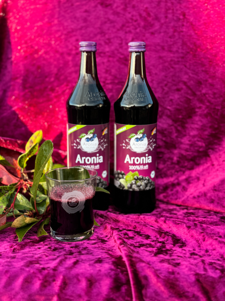 To flasker Aronia saft og et glas juice