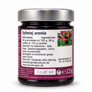 Glas med aronia-syltetøj på hvid baggrund